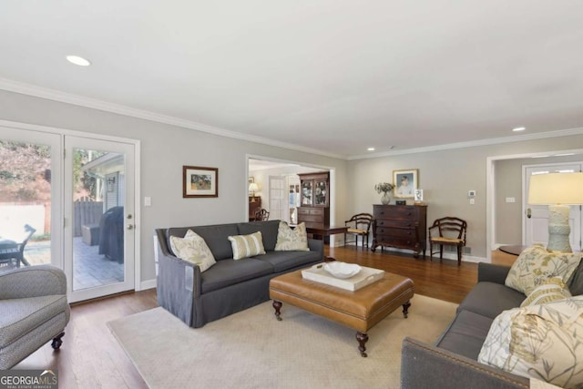 living room with recessed lighting, ornamental molding, baseboards, and wood finished floors