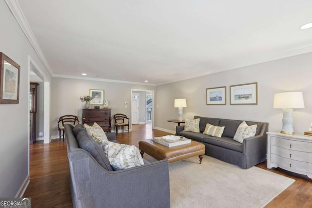 living area featuring baseboards, wood finished floors, and crown molding