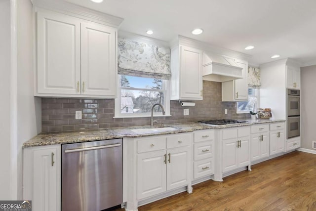 kitchen featuring white cabinetry, light wood finished floors, appliances with stainless steel finishes, and a sink