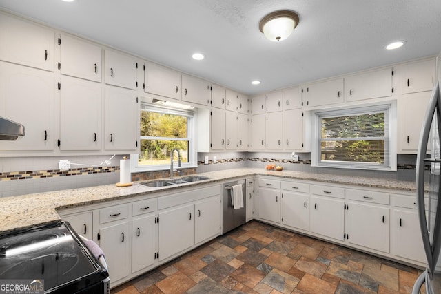 kitchen with a sink, backsplash, appliances with stainless steel finishes, and white cabinets