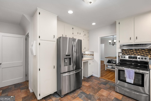 kitchen with white cabinetry, stone finish floor, under cabinet range hood, and stainless steel appliances