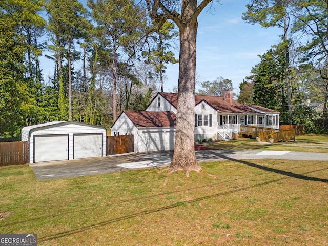 view of front of home featuring an outdoor structure, a front yard, a garage, and fence