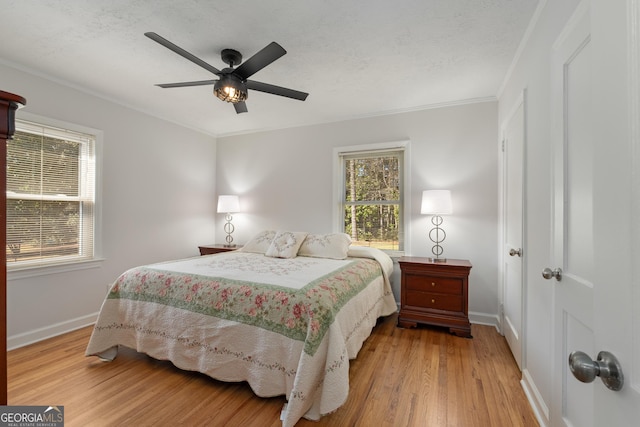 bedroom featuring crown molding, baseboards, and wood finished floors