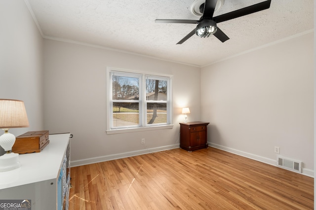 unfurnished bedroom with visible vents, crown molding, a textured ceiling, and light wood-type flooring