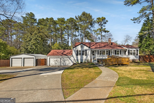 view of front facade featuring an outbuilding, a front lawn, a porch, fence, and a chimney