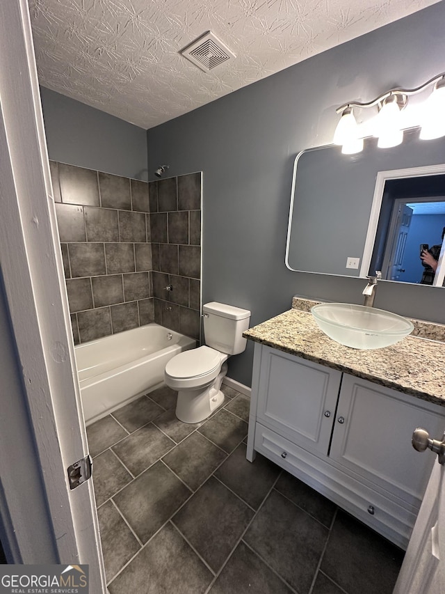 full bath with a textured ceiling, toilet, vanity, visible vents, and washtub / shower combination