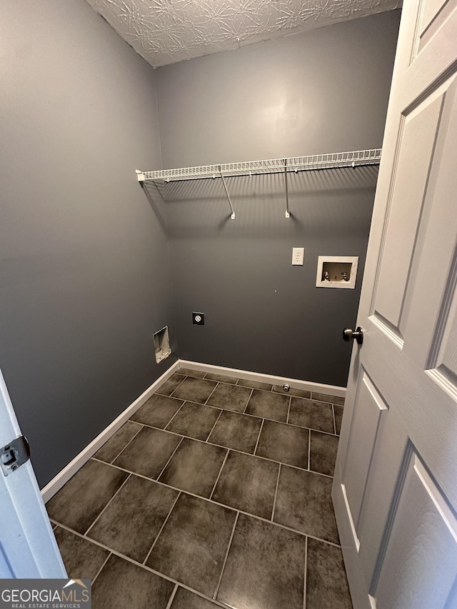 washroom featuring hookup for a washing machine, hookup for an electric dryer, dark tile patterned flooring, laundry area, and baseboards