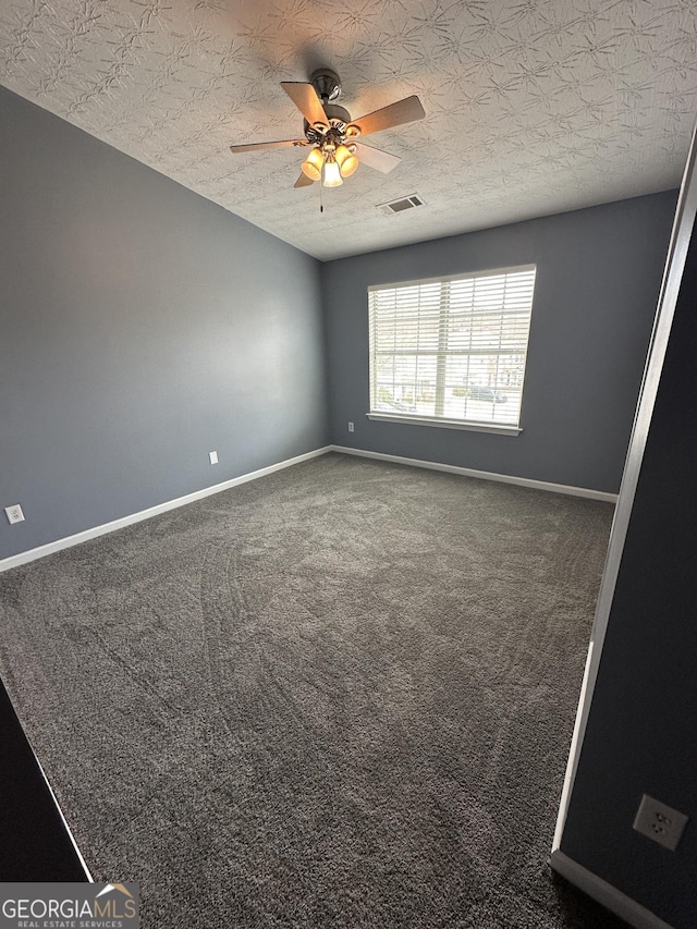 empty room with baseboards, visible vents, a ceiling fan, a textured ceiling, and carpet flooring