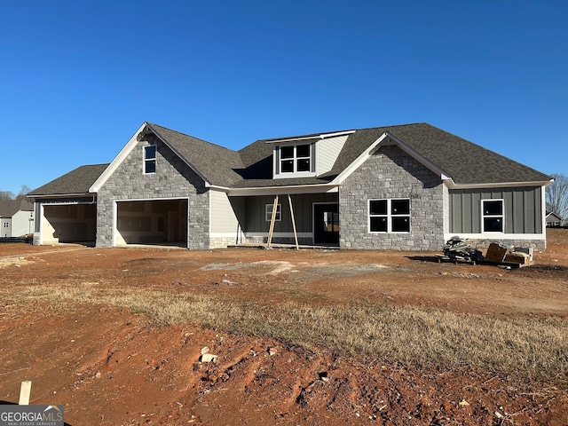 view of front of property with stone siding, board and batten siding, a shingled roof, and a porch