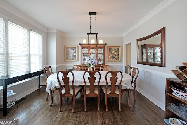 dining area featuring a notable chandelier, dark wood-type flooring, baseboards, and ornamental molding