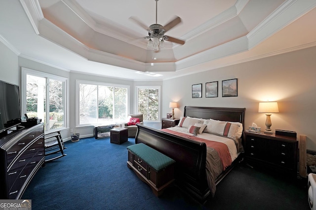 bedroom featuring ceiling fan, a tray ceiling, ornamental molding, and dark carpet