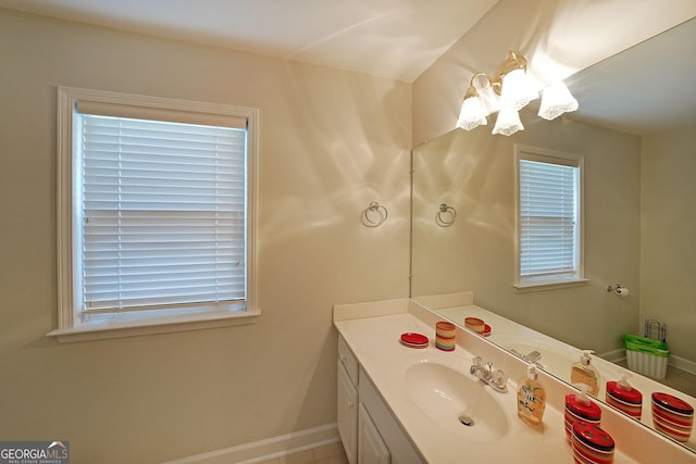 bathroom with an inviting chandelier, vanity, and baseboards