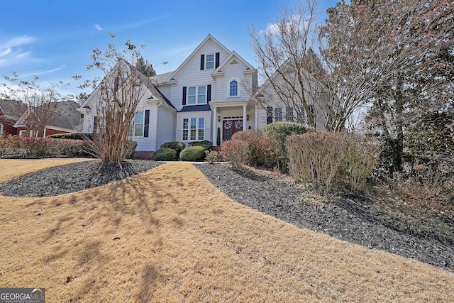 traditional-style home featuring a front lawn