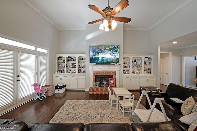 living room featuring a wealth of natural light, dark wood finished floors, a fireplace, and crown molding