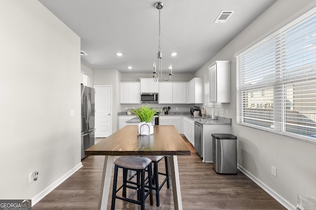 kitchen with stainless steel appliances, dark wood-style flooring, white cabinets, and baseboards