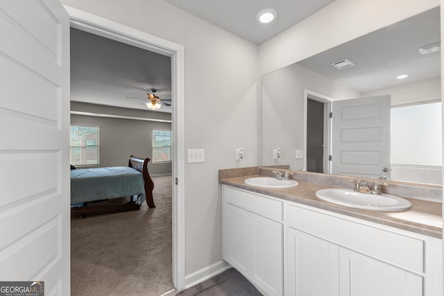 full bathroom with double vanity, ceiling fan, connected bathroom, and a sink