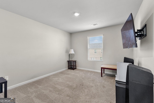 office area featuring visible vents, baseboards, and light colored carpet