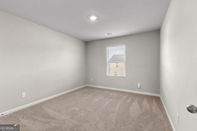 spare room with carpet, visible vents, and baseboards