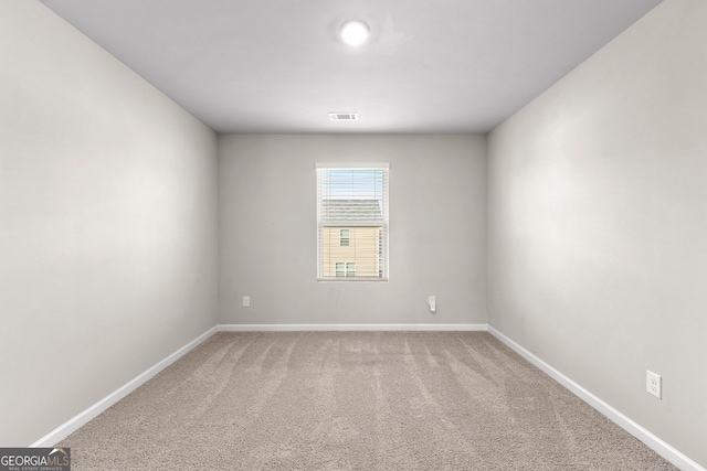 unfurnished room featuring visible vents, light carpet, and baseboards