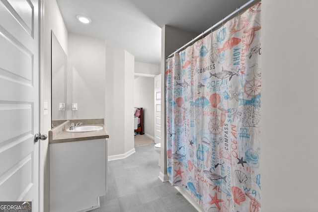 bathroom with curtained shower, toilet, vanity, baseboards, and tile patterned floors