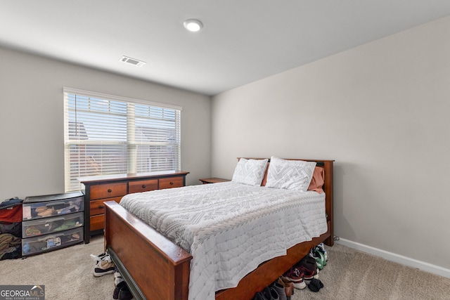 bedroom featuring baseboards, visible vents, and light colored carpet