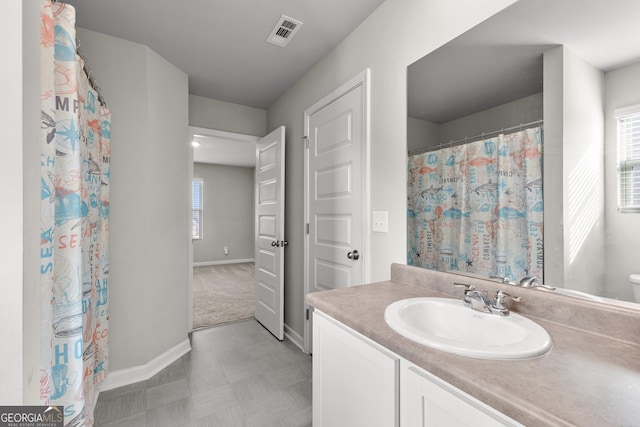 full bath featuring baseboards, visible vents, a wealth of natural light, and vanity