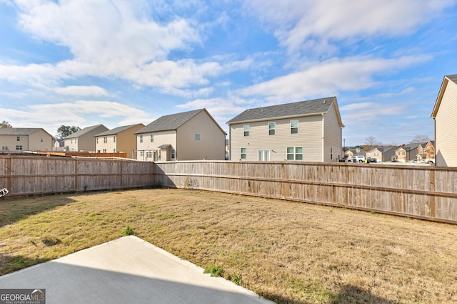 view of yard featuring a fenced backyard, a residential view, and a patio