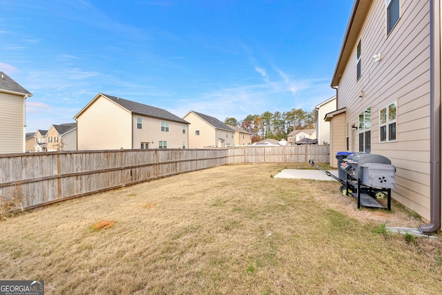 view of yard with a residential view, a patio area, and a fenced backyard