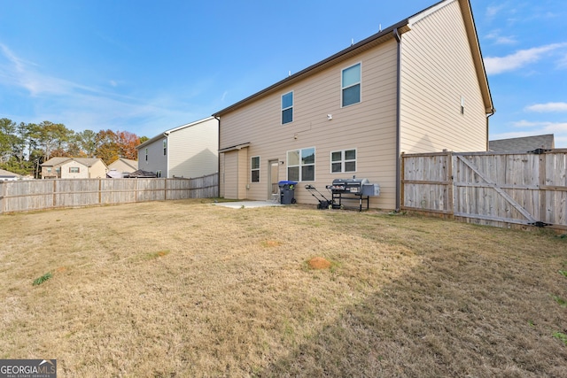 rear view of property featuring a fenced backyard, a lawn, and a patio