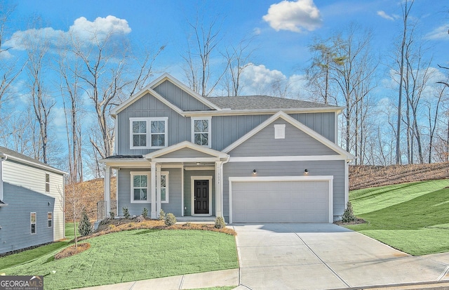 view of front of house with a garage, driveway, a porch, board and batten siding, and a front yard