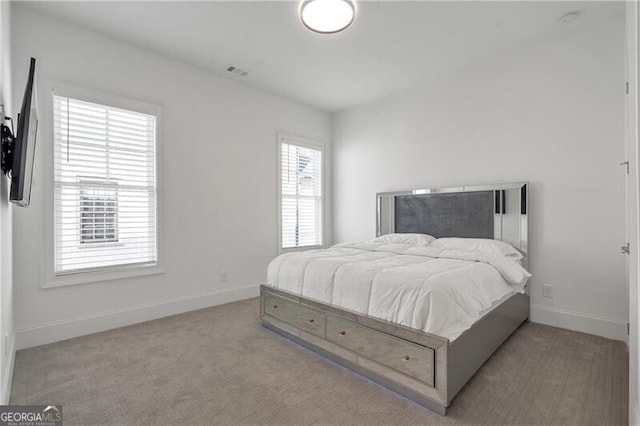 carpeted bedroom featuring visible vents and baseboards