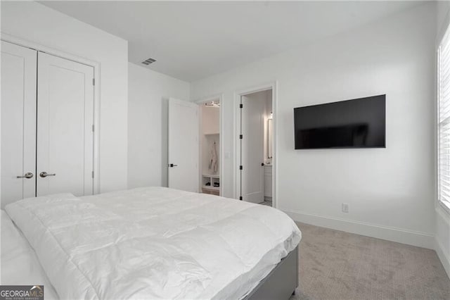 bedroom featuring baseboards, a closet, visible vents, and light colored carpet