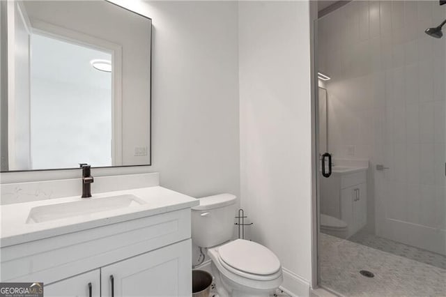 bathroom featuring toilet, a shower stall, and vanity