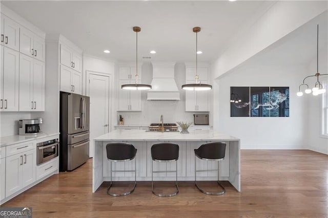 kitchen with white cabinetry, premium range hood, and appliances with stainless steel finishes