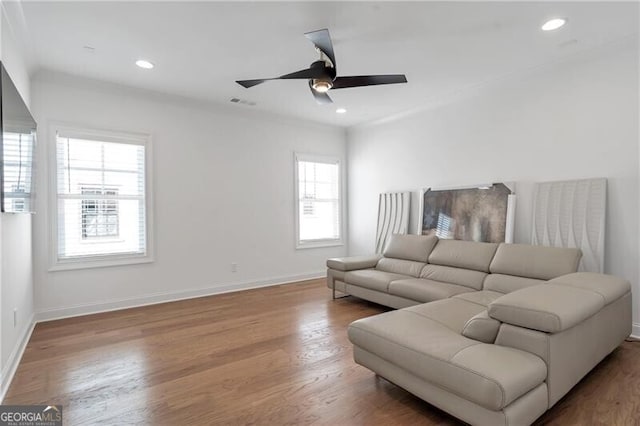 living room with baseboards, wood finished floors, and recessed lighting