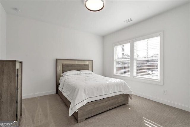 carpeted bedroom featuring baseboards and visible vents