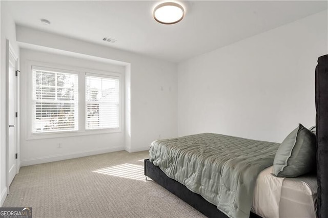 bedroom with light carpet, visible vents, and baseboards