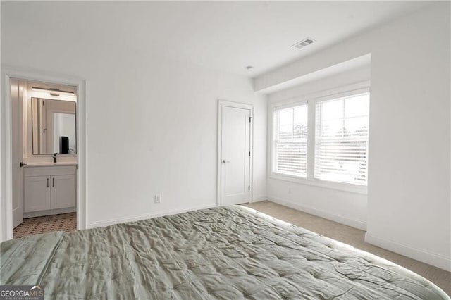 unfurnished bedroom featuring baseboards, visible vents, a sink, and ensuite bathroom