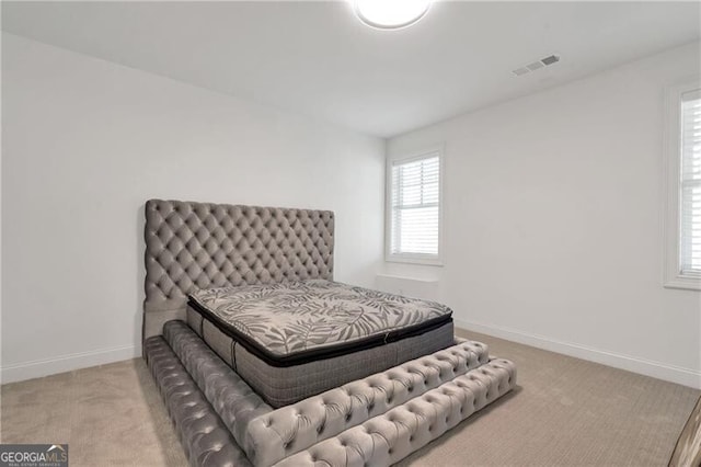 carpeted bedroom featuring visible vents and baseboards