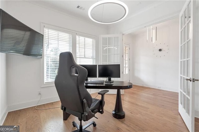 office featuring light wood-type flooring, french doors, visible vents, and baseboards