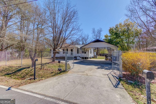 view of front of home with concrete driveway, fence, and a gate