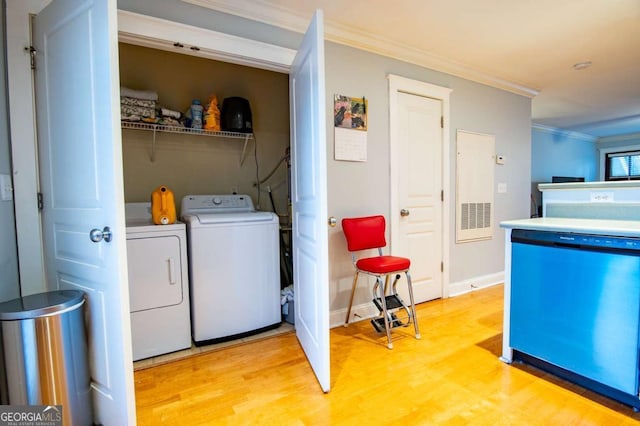 washroom with laundry area, baseboards, washing machine and clothes dryer, crown molding, and light wood-style floors