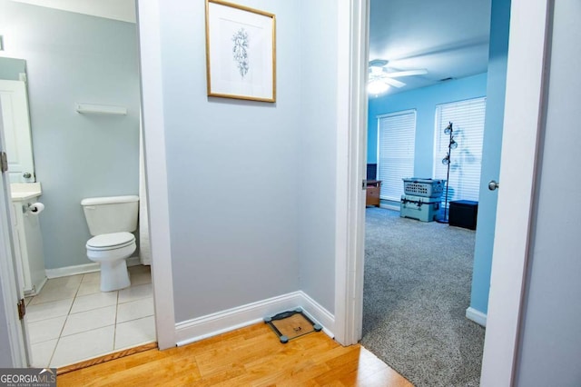 bathroom featuring ceiling fan, tile patterned floors, toilet, and baseboards