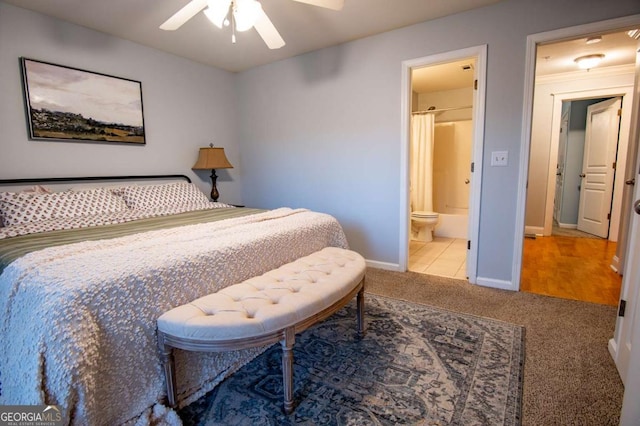 bedroom with carpet floors, connected bathroom, a ceiling fan, and baseboards