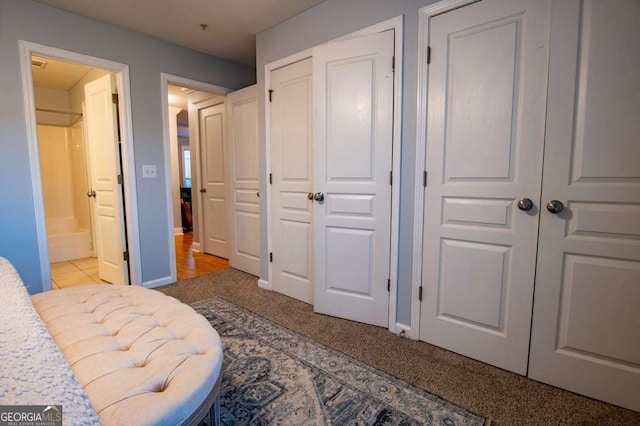 carpeted bedroom with baseboards and ensuite bathroom