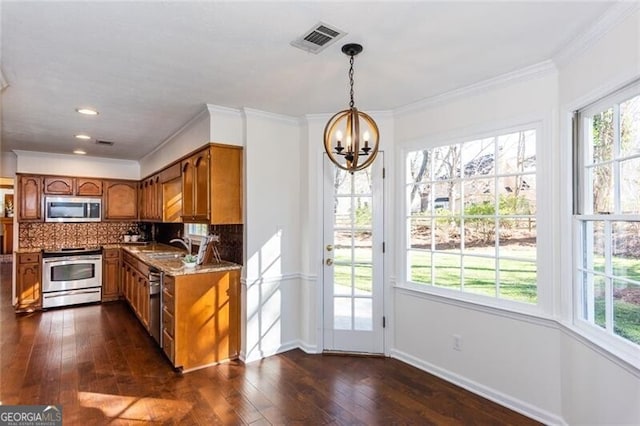 kitchen with brown cabinetry, visible vents, stainless steel appliances, and decorative backsplash