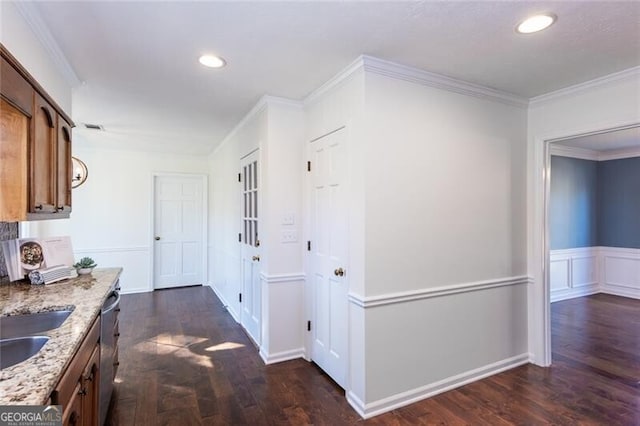 corridor with recessed lighting, ornamental molding, dark wood finished floors, and wainscoting