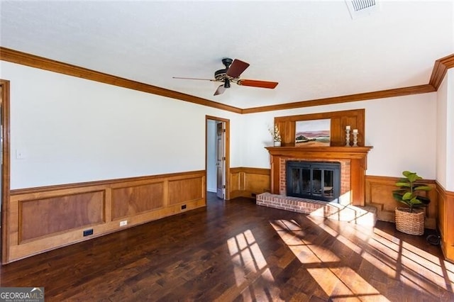 unfurnished living room with a fireplace, visible vents, dark wood finished floors, and wainscoting