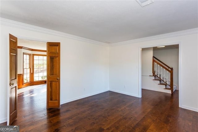 empty room with dark wood-style floors, visible vents, ornamental molding, and stairs