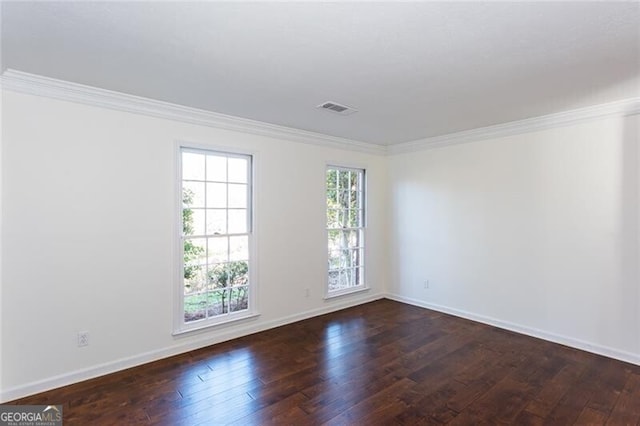 empty room featuring ornamental molding, dark wood-style flooring, and baseboards